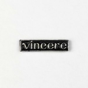 Pin in metallo smaltato raffigurante una targhetta col motto “Vincere”